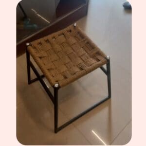 Woven rattan stool with metal frame, stylish modern furniture for home decor.