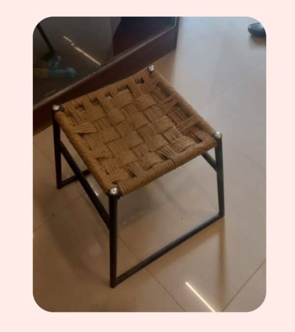 Woven rattan stool with metal frame, stylish modern furniture for home decor.